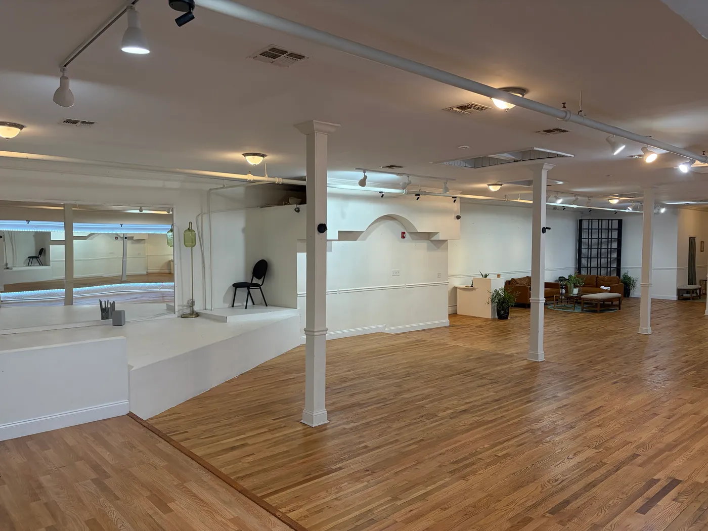The open main floor with its low stage, white columns and lounge seating at the far end