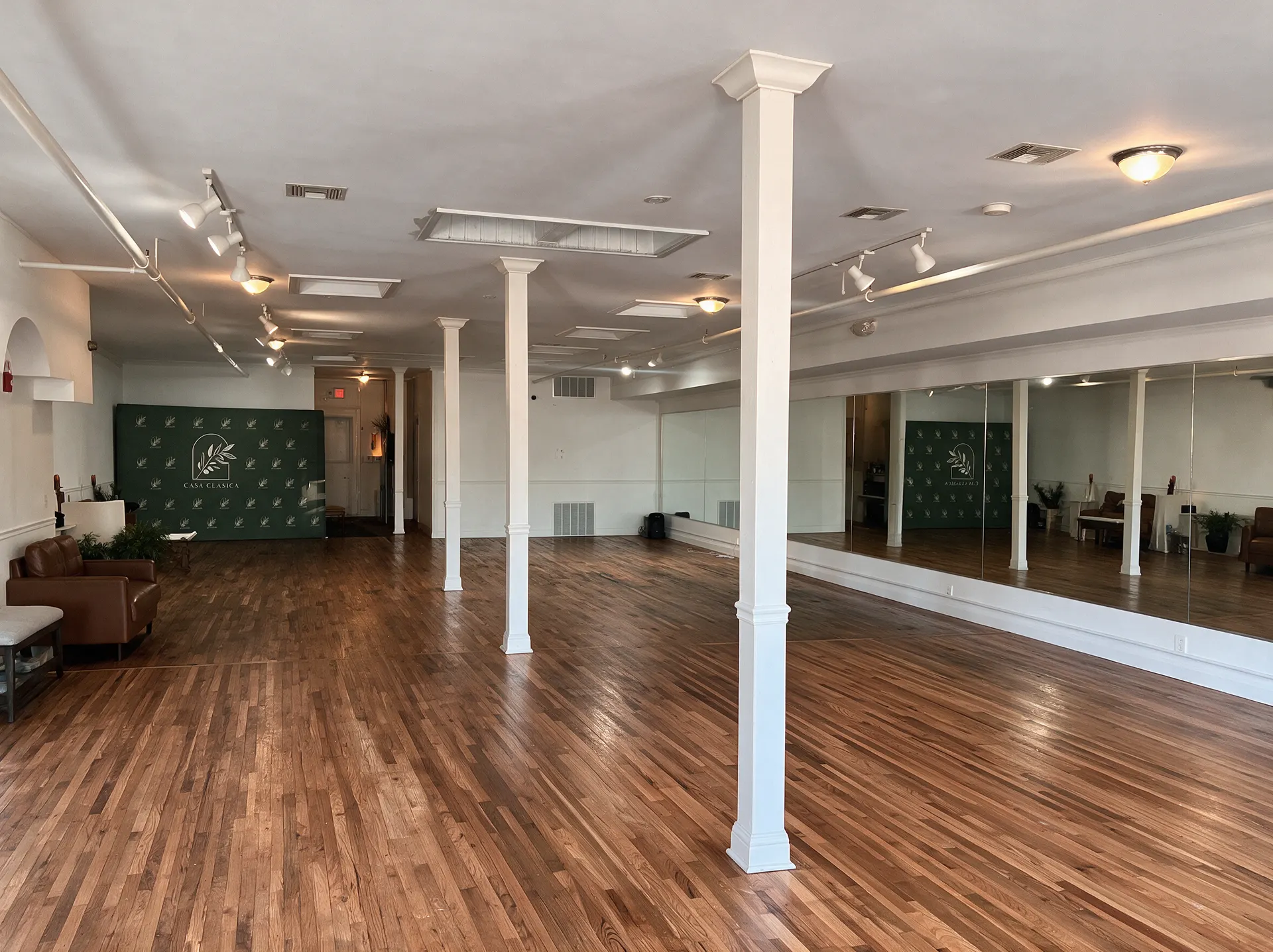 Casa Alegría's light-filled studio floor in Asbury Park, with plants, mirrors, and open windows